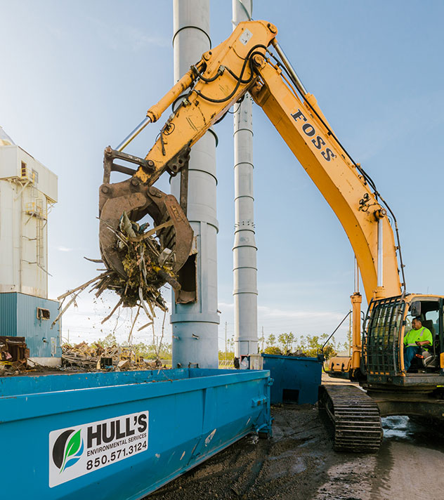 Machine dumping recyclable metal into dumpster