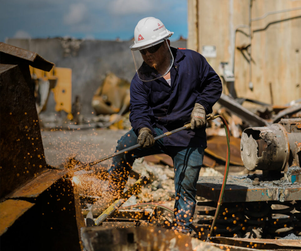 Man cutting apart metal